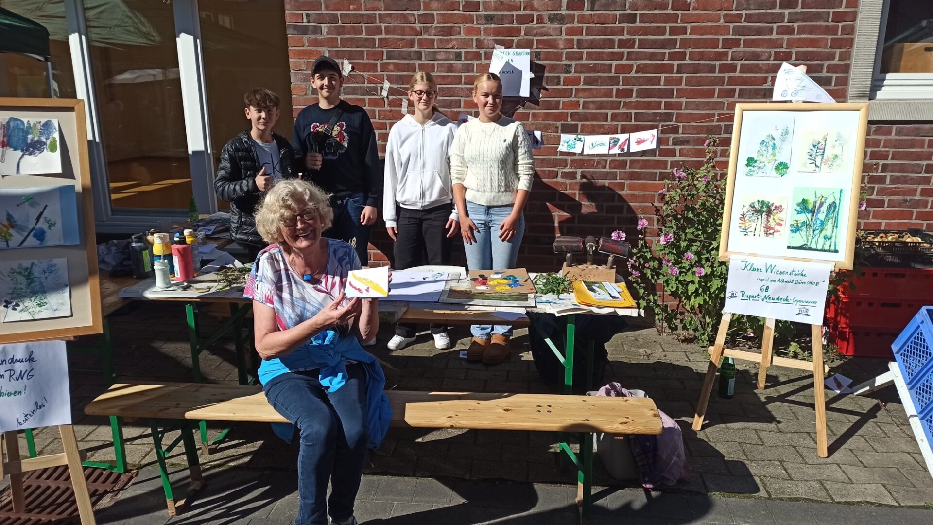 Auf dem Bild sieht man Schülerinnen und Schüler hinter ihrem Pflanzendruckstand. 