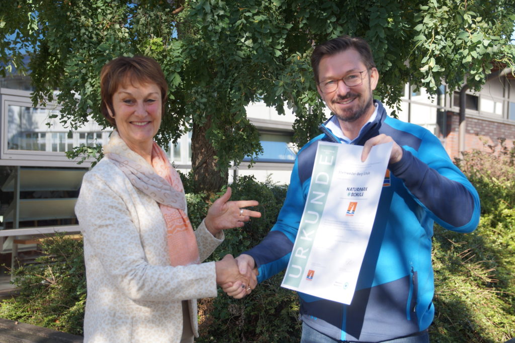 Detlef Tänzer vom Naturpark Dümmer e.V. übergibt Schulleiterin Heike Hachmann die Rezertifizierungsurkunde