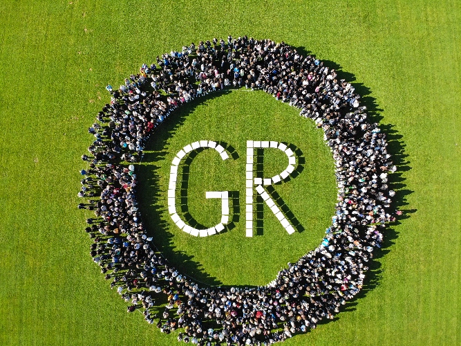 Logo des Gymnasiums Remigianum/ Mit einer Drohne wurde die Schülerinnen und Schüler auf einer Wiese das GR Logo bildend aufgenommen. 