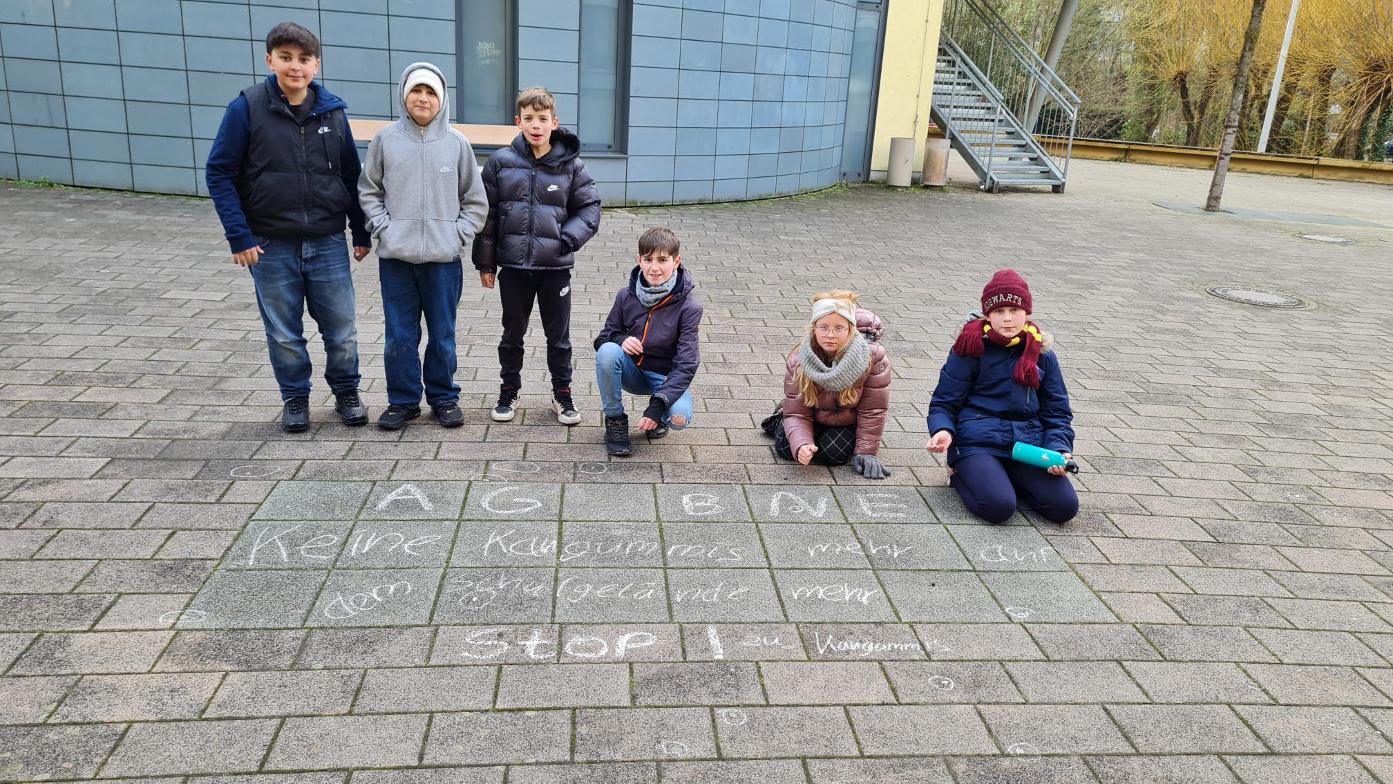 Schüler*innen beim Markieren von Kaugummis auf dem Schulhof