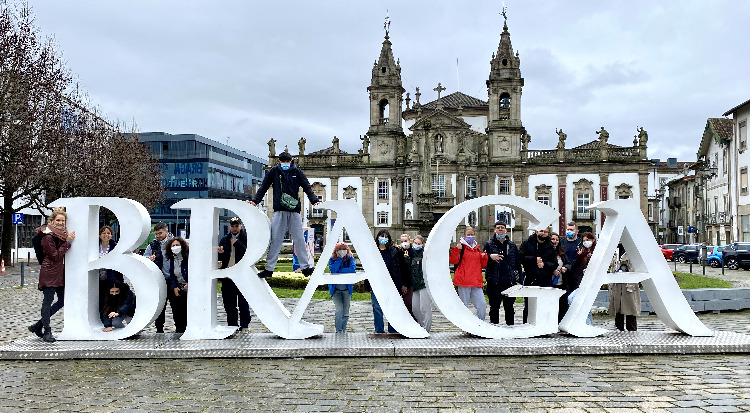 Schüler*innen und begleitende Lehrerinnen stehen an einem überdimensionalen Schriftzug „Braga“ in der Stadt Braga. 