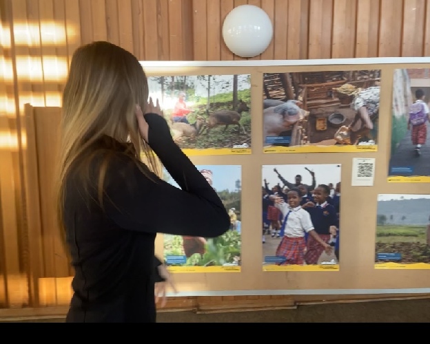 Eine Schülerin betrachtet Fotos aus der Ausstellung „Empowerment“, die Bilder aus Unterstützungsprojekten in Afrika zeigt.